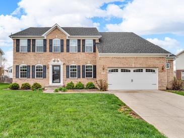 Inviting two-story brick home with manicured lawn and a two-car garage on a sunny day at 1968 Saratoga Dr, Greenwood, IN 46143