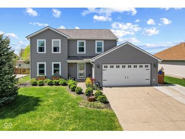Charming two-story home with a well-manicured lawn, beautiful landscaping, and a two-car garage at 272 Van Buren St, Greenfield, IN 46140