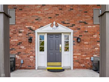 Charming brick exterior with a gray front door and decorative white trim, offering a warm welcome to this lovely home at 3127 E 52Nd St # C, Indianapolis, IN 46205