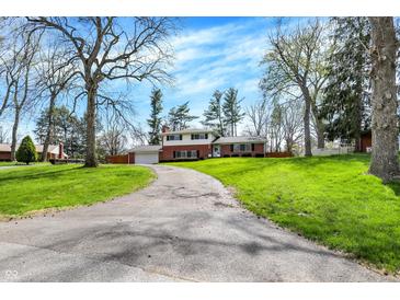 Charming two-story brick home featuring an inviting front yard and a long driveway at 4260 Springwood Trl, Indianapolis, IN 46228