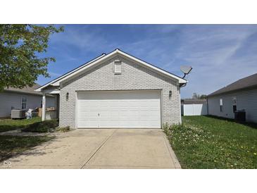 A garage with a white door, grey brick, and a satellite dish above the door at 5609 Sweet River Dr, Indianapolis, IN 46221