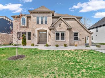 Stunning brick home featuring a manicured lawn, elegant landscaping, and a welcoming front entrance at 6044 Shallow Crk Ln, Indianapolis, IN 46237