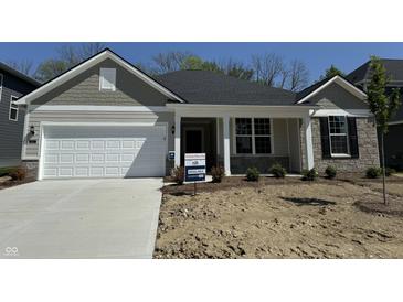 Charming single-story home showcasing a two-car garage and manicured front yard at 6474 Ambassador Dr, Plainfield, IN 46168