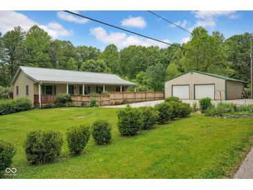 Inviting home featuring a charming porch, well-manicured lawn, and a convenient two-car detached garage at 685 N Buffalo Hill Rd, Martinsville, IN 46151