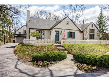 Charming home with a manicured lawn, flower beds, and a white picket fence offering wonderful curb appeal at 7845 Allisonville Rd, Indianapolis, IN 46250