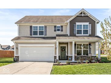 Charming two-story home with a covered front porch and an attached two-car garage at 7901 Apalachee Dr, Indianapolis, IN 46217