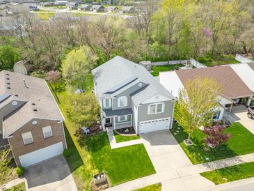 Aerial view of a charming two-story home with a well-maintained lawn and mature trees at 853 Westpointe Dr, Shelbyville, IN 46176