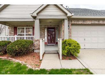 Inviting brick home featuring a charming front porch and well-maintained landscaping, a warm welcome to visitors at 8618 Turnstone Ct, Indianapolis, IN 46234