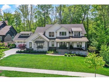 Charming two-story home with a beautifully landscaped lawn and a welcoming front porch at 10725 Holliday Farms Blvd, Zionsville, IN 46077