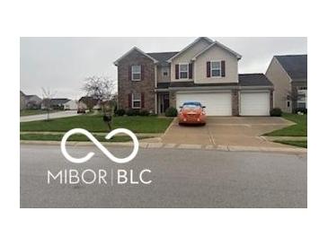 Charming two-story home with a three-car garage and well-maintained lawn at 11555 Ross Common Dr, Indianapolis, IN 46229