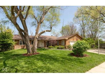 Charming single-story home with a well-manicured lawn and mature tree at 1186 Castle Dr, Franklin, IN 46131