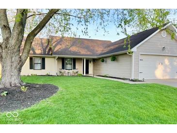 Charming single-story home with well-maintained lawn, complemented by black shutters and a two-car attached garage at 12005 Hardwick Dr, Fishers, IN 46038