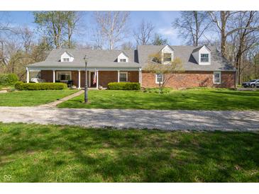 Charming brick home featuring a spacious front yard, covered porch, and classic dormer windows at 2394 W 600 S, New Palestine, IN 46163