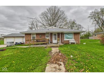 Quaint brick home with a ramp leading to the front door and a spacious yard with dandelions at 306 W Clyde St, Frankton, IN 46044