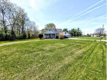 Charming home featuring a well-maintained lawn, mature trees, and an American flag at 3514 Carson Ave, Indianapolis, IN 46227