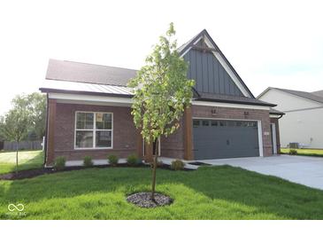 Charming brick home featuring a manicured lawn and attached two-car garage, enhancing curb appeal at 5052 Carmine St, Brownsburg, IN 46112