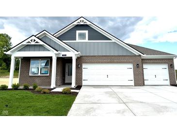 Charming new construction home with brick and gray siding and a three car garage at 5924 Trichel Dr, Greenwood, IN 46143