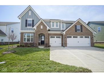 Charming two-story home with brick and gray siding, attached two-car garage, and well-manicured lawn at 613 Waterford Ln, Westfield, IN 46074
