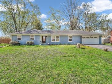 Charming single-story home features a manicured front lawn, blue painted brick exterior, and an attached two-car garage at 7671 Sherry Ln, Brownsburg, IN 46112