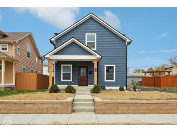 Charming two-story blue home featuring a new front yard, brick retaining wall, wood accents, and inviting entrance at 1158 Burdsal Pkwy, Indianapolis, IN 46208