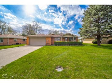 Charming single-story home with a well-maintained lawn and inviting curb appeal with mature trees at 1507 Lynnwood Dr, Anderson, IN 46012