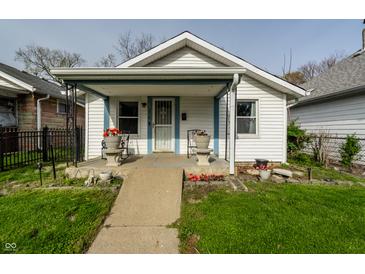Charming single-Gathering home with a cozy front porch, landscaped with flowers, and a well-maintained lawn at 1510 Asbury St, Indianapolis, IN 46203