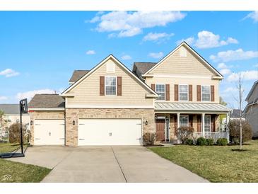 Charming home with a two-car garage, stone accents, and a well-maintained lawn at 16271 Ambia Cir, Westfield, IN 46074
