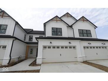 Modern townhome featuring a white exterior, black trim, a two-car garage, and natural wood accents at 17458 Ebling Trl, Westfield, IN 46062