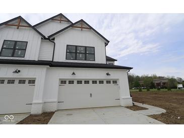 Newly constructed modern farmhouse featuring white siding, a black roof, and two-car garage with a concrete driveway at 17466 Ebling Trl, Westfield, IN 46062