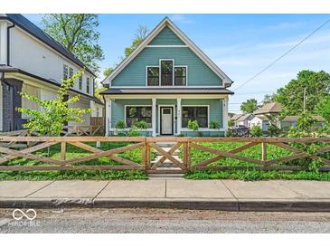 Charming two-story home featuring a decorative wooden fence and freshly manicured lawn at 401 Sanders St, Indianapolis, IN 46225