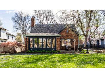 Charming brick home featuring a beautifully landscaped front yard and enclosed sunroom at 5331 N New Jersey St, Indianapolis, IN 46220