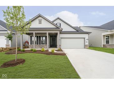 Charming home with landscaped yard, covered porch, and two-car garage offers great curb appeal at 5661 Stetson Dr, Whitestown, IN 46052
