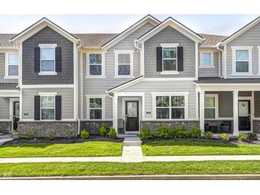 Charming townhome featuring stone accents, gray siding, black shutters, and a well-manicured front lawn at 7265 Governors Row, Avon, IN 46123