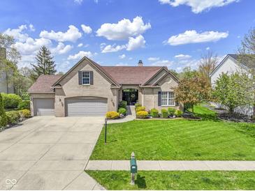 Charming single-story brick home with a three-car garage and beautifully landscaped front yard at 8324 Thorn Bend Dr, Indianapolis, IN 46278