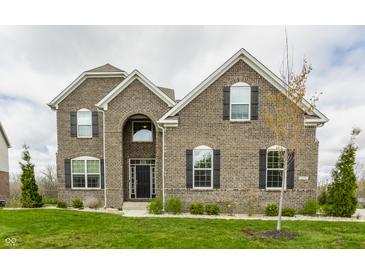 Stunning two-story brick home with manicured lawn and dark shutters against a cloudy sky at 8330 Dumfries Dr, Brownsburg, IN 46112
