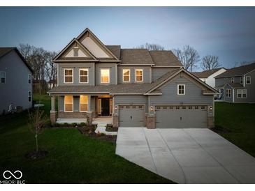 Charming two-story home with three-car garage and well-manicured lawn at 10423 Hamburg Dr, Fortville, IN 46040