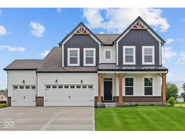 Striking two-story home with a three car garage, craftsman details and a well-manicured lawn at 1114 Ridgevine Rd, Greenwood, IN 46143
