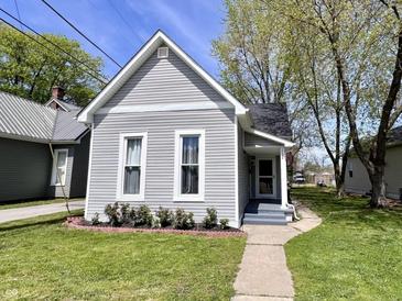 Charming home featuring gray siding, updated windows, and a well-maintained lawn with small garden bed at 2022 Indiana Ave, Columbus, IN 47201