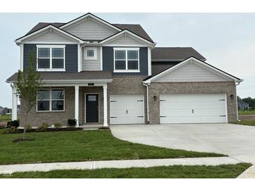 Charming two-story home featuring a two-car garage, manicured lawn, and a blend of brick and siding accents at 210 Aster Way, Greenfield, IN 46140