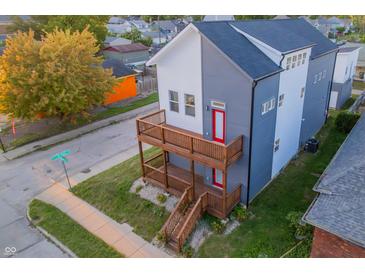 Modern two-story home featuring a gray and white color scheme and a double wooden balcony at 2302 Prospect St, Indianapolis, IN 46203