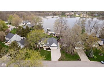Aerial view of a home near a lake with mature trees and meticulous landscaping at 2428 Hawthorn Pl, Noblesville, IN 46062