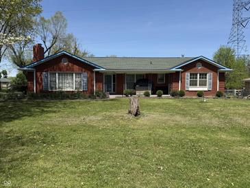 Charming one-story brick home with a well-manicured front yard and blue trim at 244 E Cragmont Dr, Indianapolis, IN 46227