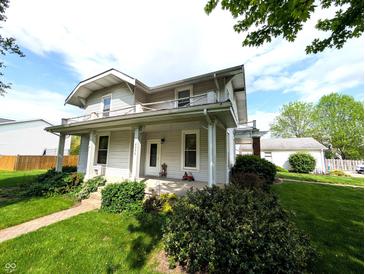 Charming two-story home with a covered front porch and landscaped yard, perfect for relaxation at 4335 River Rd, Columbus, IN 47203