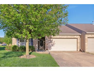 Charming brick home featuring an attached garage and lush lawn with a mature shade tree at 6017 Riva Ridge Dr, Indianapolis, IN 46237