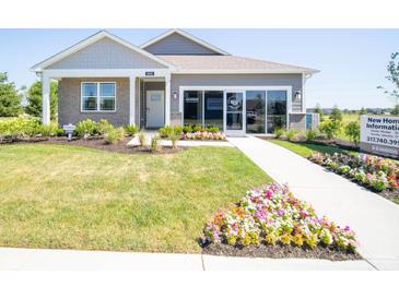 Charming single-story home featuring a manicured lawn, inviting walkway, and blooming flowerbeds at 8502 Hemingway Dr, Indianapolis, IN 46239