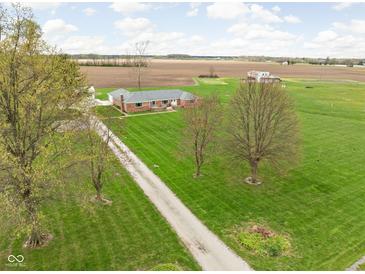 Sprawling single story brick home on expansive green lawn in a rural setting at 10239 Wilson Rd, Brownsburg, IN 46112