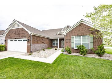 Charming brick home featuring a manicured lawn, two-car garage, and inviting walkway at 14014 Fieldcrest Dr, McCordsville, IN 46055