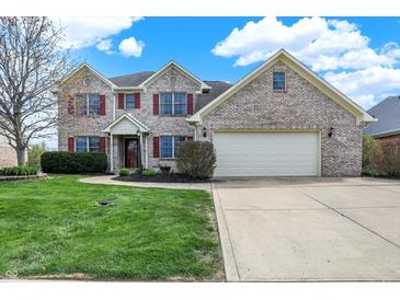 Charming two-story home with a well-manicured lawn, brick exterior and two car garage at 1611 Connemara Rd, Indianapolis, IN 46217