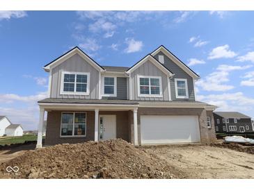 New construction home featuring gray siding, a brick facade, and an attached two-car garage at 17062 Cowbell Dr, Noblesville, IN 46060