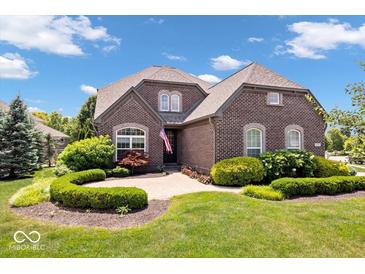 Charming brick home with well-manicured front yard, lush greenery, and beautiful landscaping at 2705 April Springs View, Carmel, IN 46074